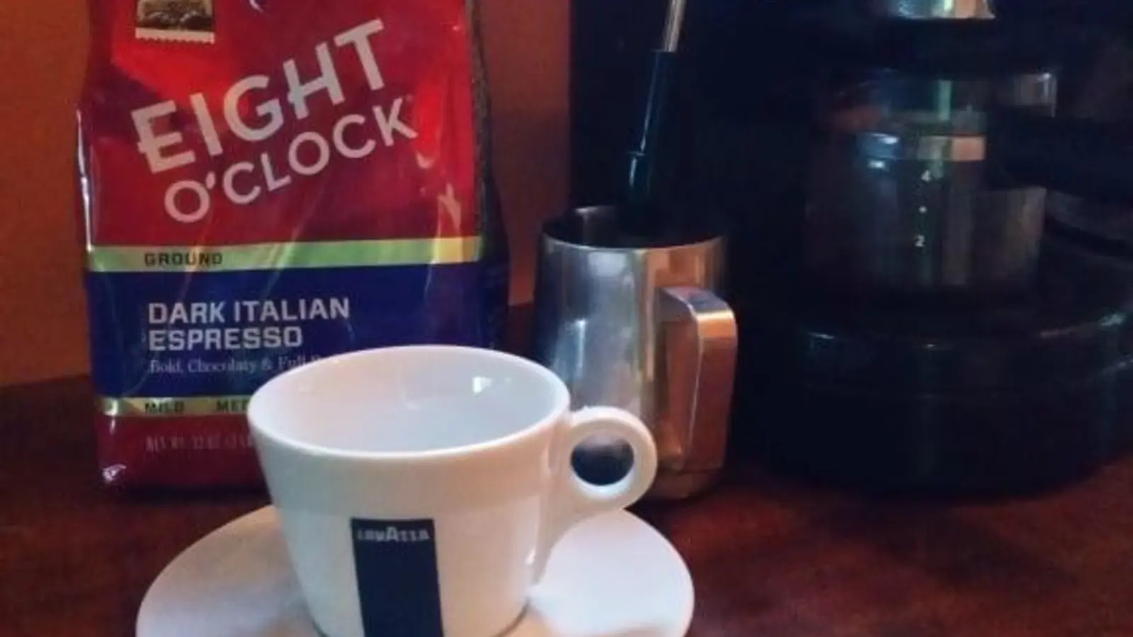 Earlier Eight O'Clock Dark Italian Espresso ground-coffee bag beside a home coffee maker