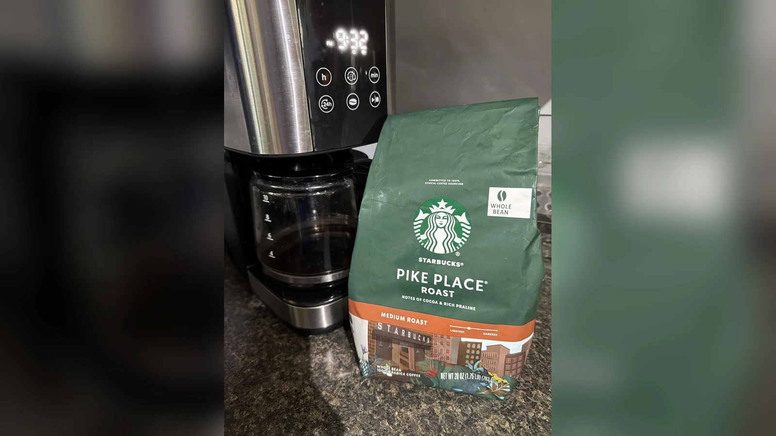 Starbucks Pike Place Roast whole-bean coffee beside an espresso machine
