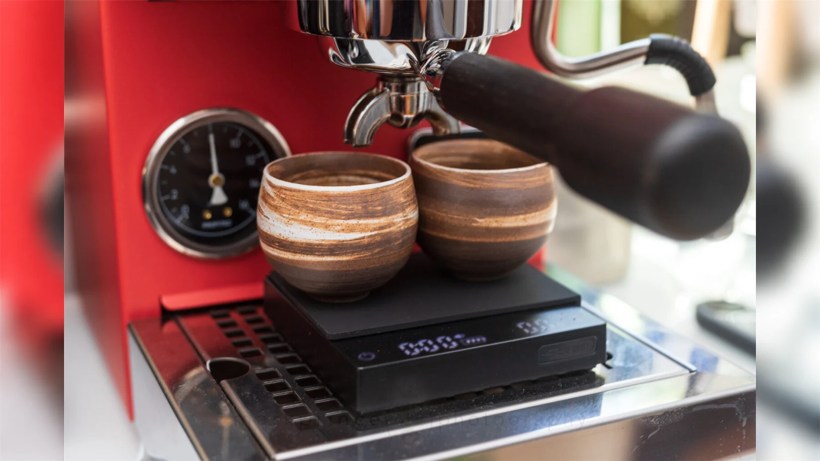 An earlier MHW-3BOMBER Cube 2.0 Mini supporting two small cups beneath an espresso portafilter