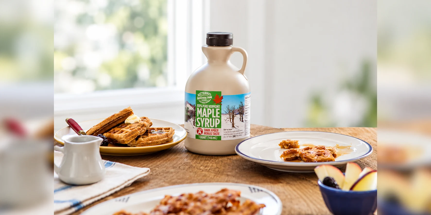 Butternut Mountain Farm quart jug of maple syrup beside waffles and breakfast plates