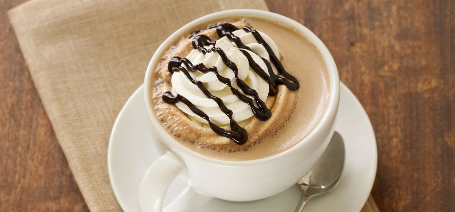 Ghirardelli mocha topped with whipped cream and a chocolate drizzle