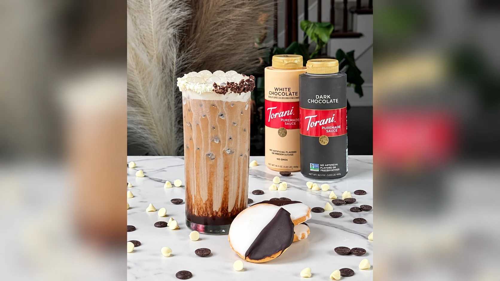 Torani dark and white chocolate sauces beside an iced cookie latte