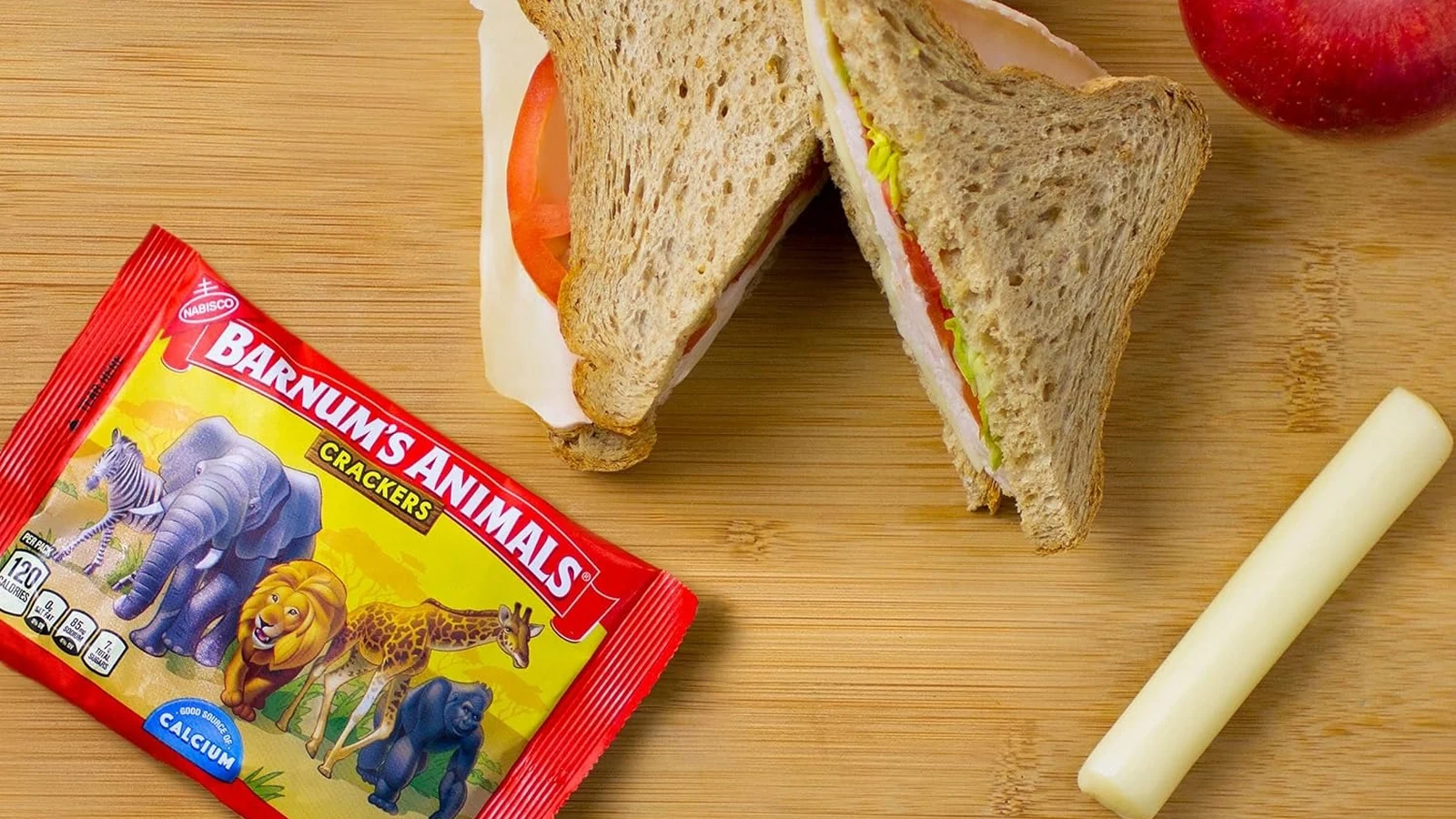 Barnum's Animal Crackers snack pack beside a sandwich, apple, and cheese