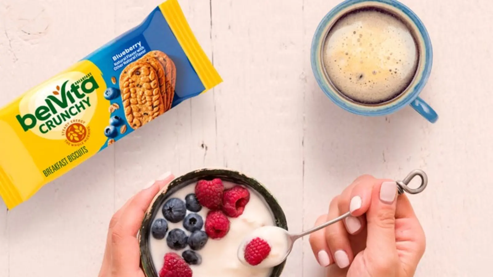 A belVita Blueberry pack with coffee, yogurt, and fresh berries