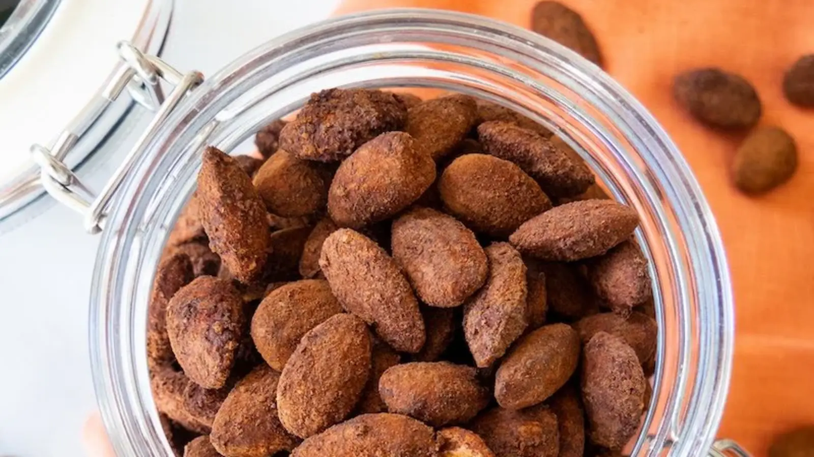 Cocoa-dusted roasted almonds in an open glass jar