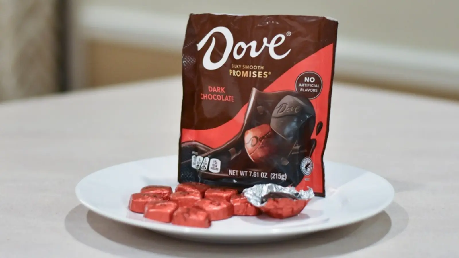 A Dove Promises dark chocolate bag with wrapped pieces on a plate