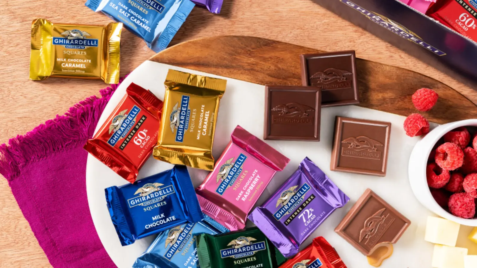 Assorted wrapped Ghirardelli chocolate squares arranged on a board