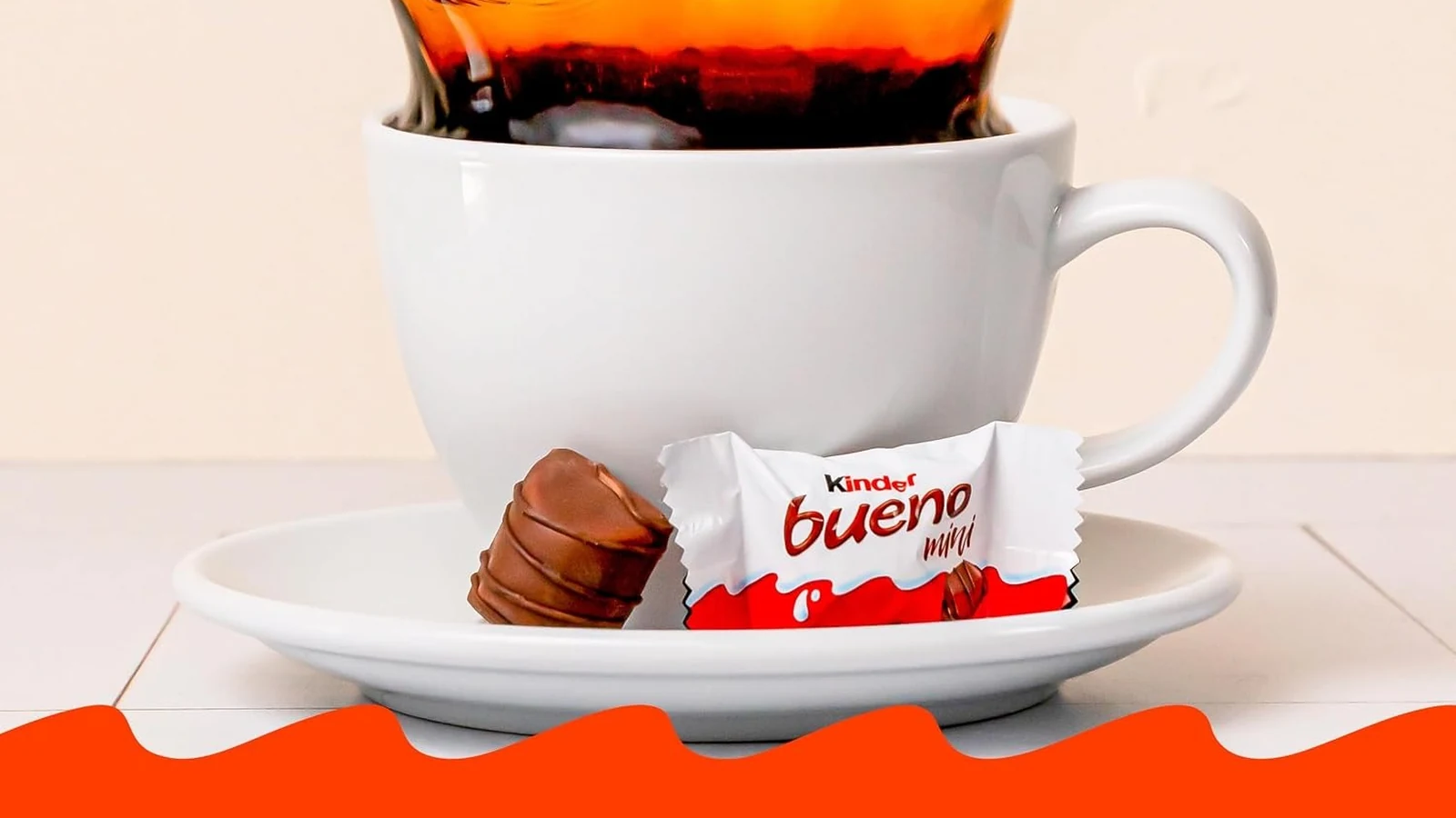 A Kinder Bueno Mini beside a white cup of coffee