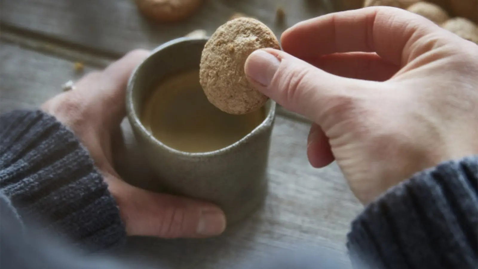 A small vanilla wafer being dipped into coffee