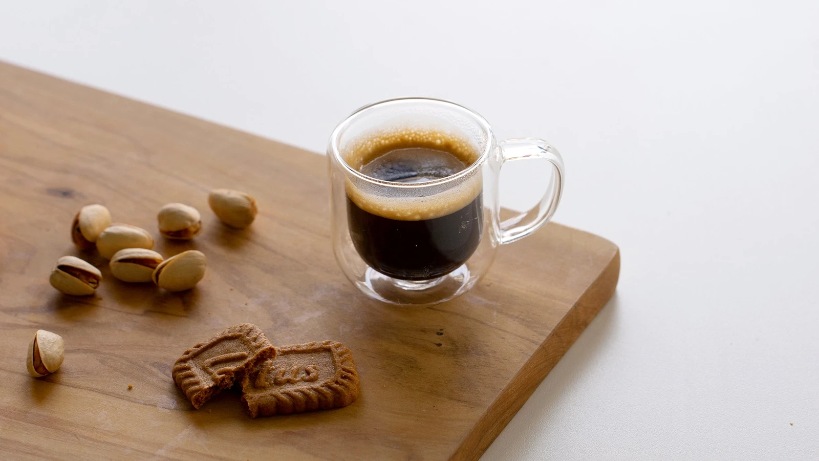 Espresso with pistachios on a wooden serving board