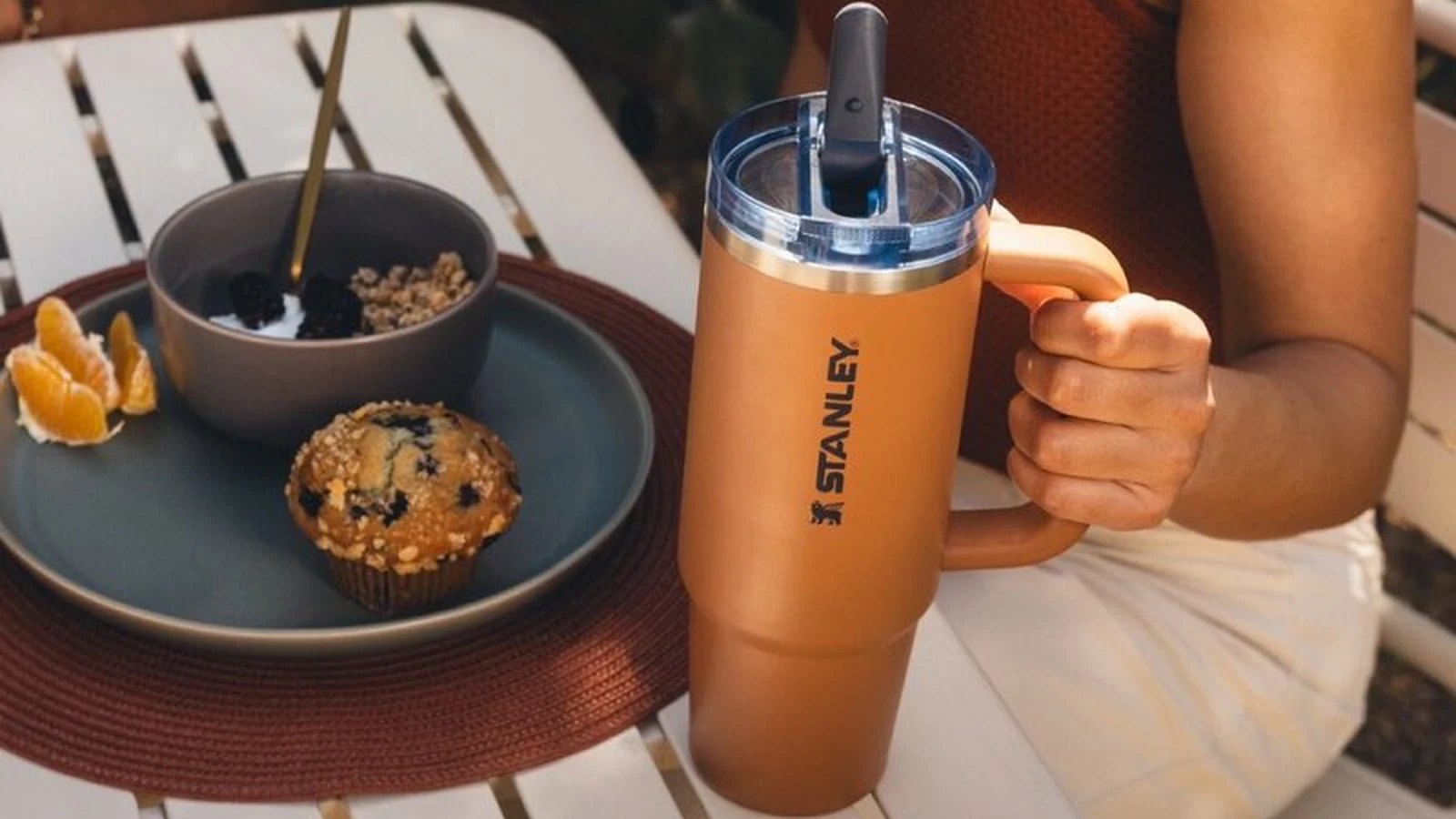 Orange Stanley Quencher ProTour 30 oz beside breakfast on a patio table