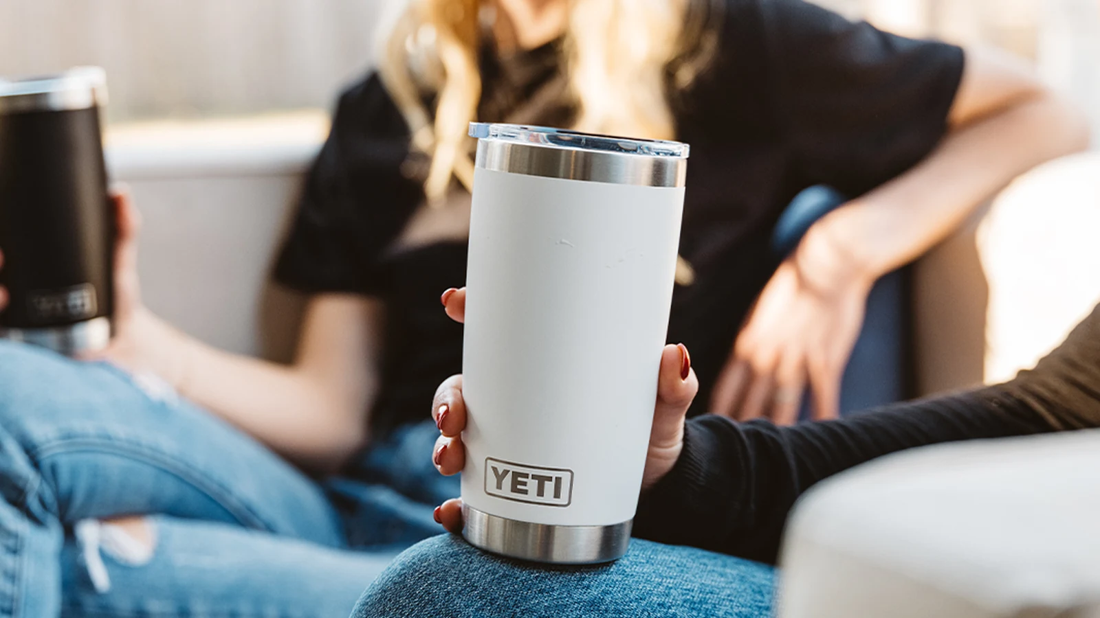 White YETI Rambler 20 oz tumbler held during a casual gathering