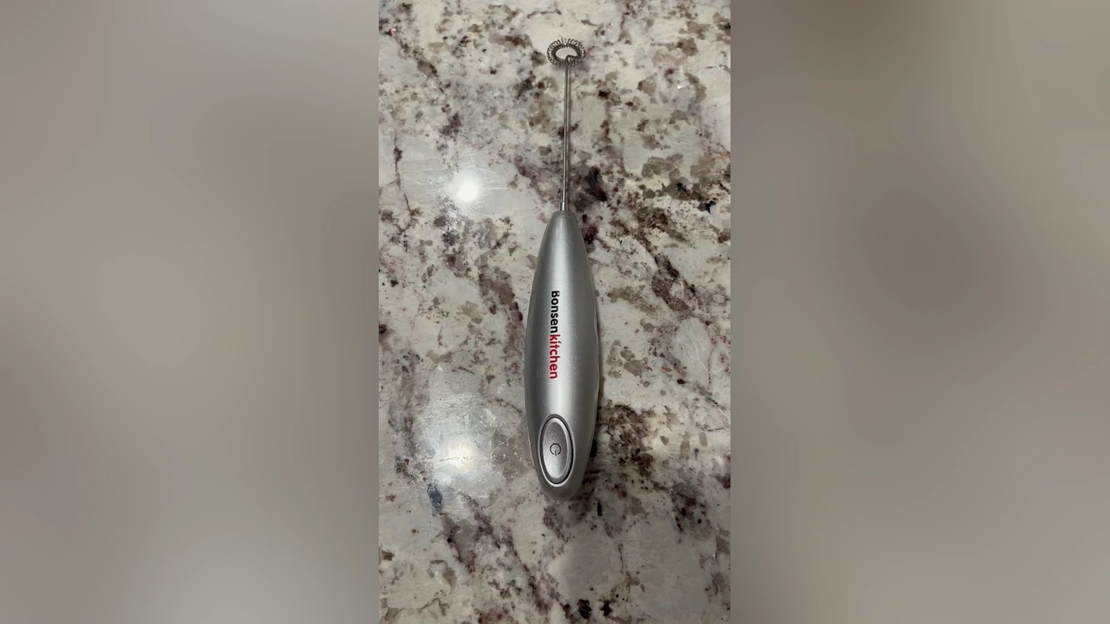 Silver Bonsenkitchen frother lying on a stone kitchen counter