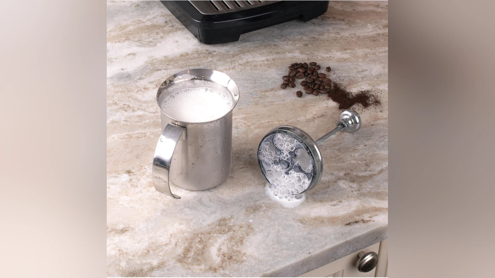 Open Fino steel pitcher filled with foam, with the double-mesh plunger beside it
