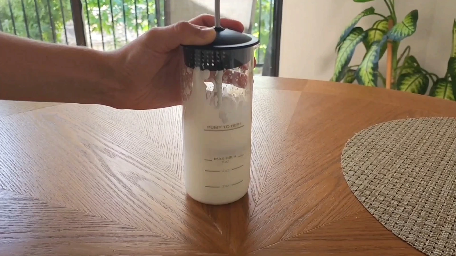 Ninja glass milk frother being pumped on a wooden table