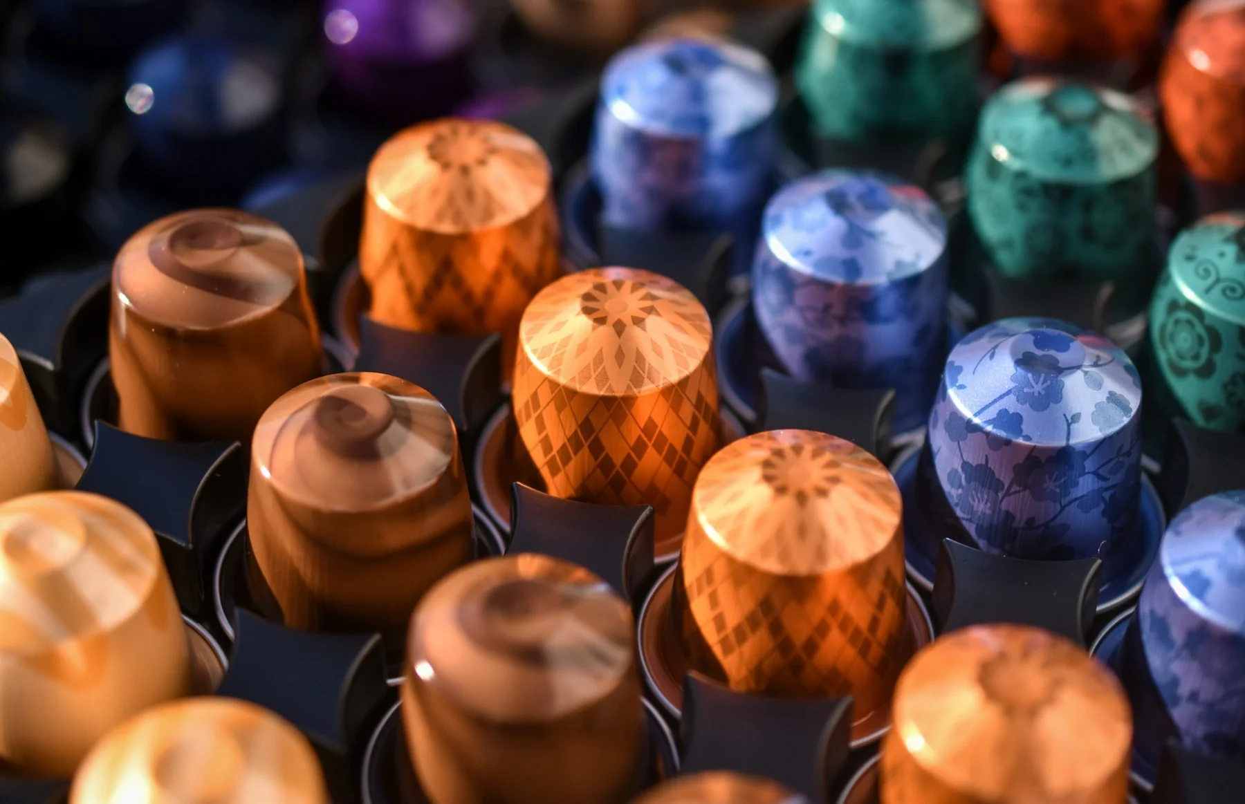Colorful Original-format coffee capsules arranged in individual slots; photo by Jesper Brouwers