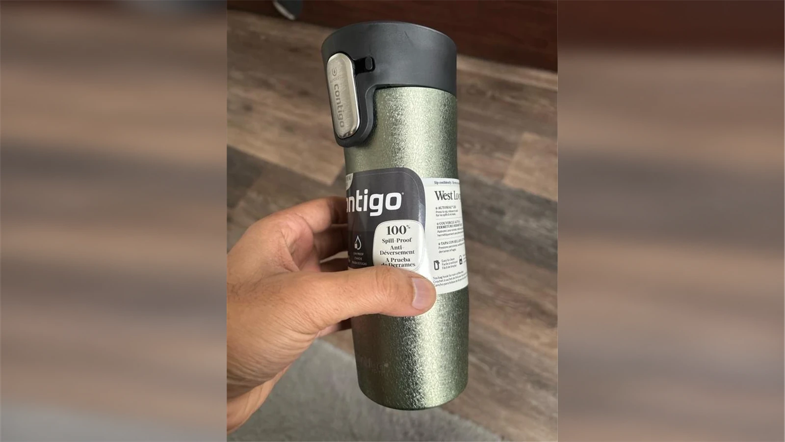 A hand holding a green Contigo West Loop 3.0 16 oz mug with its AUTOSEAL lid