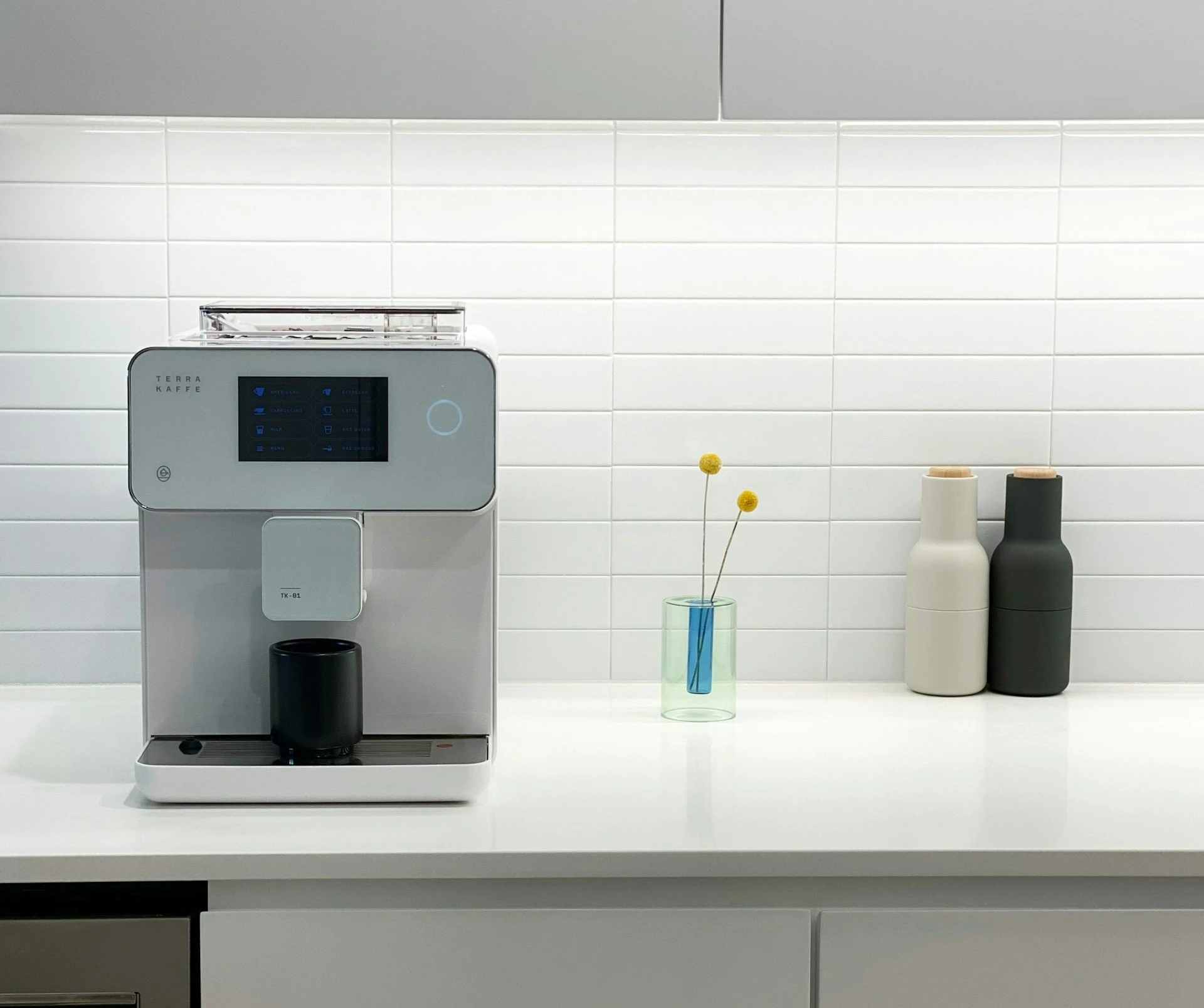 Compact espresso machine setup on a small kitchen counter with a cup and milk jug