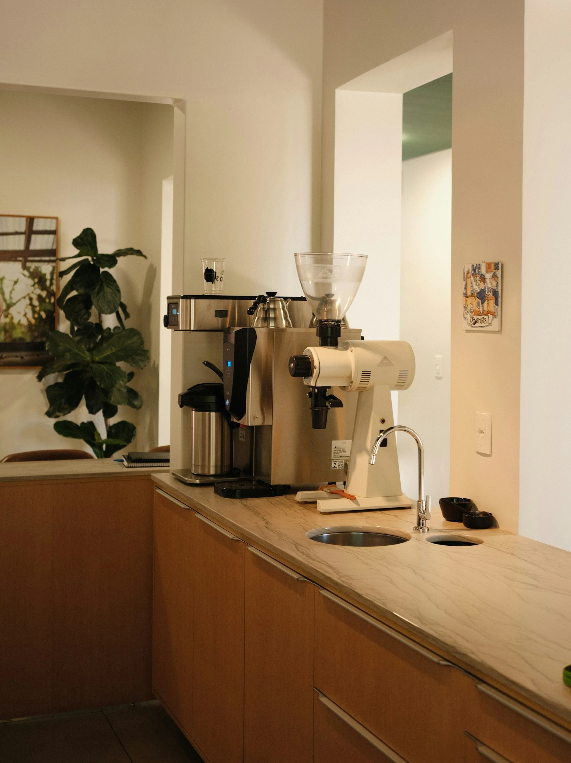 Commercial espresso grinder and brewing equipment setup in a modern café kitchen