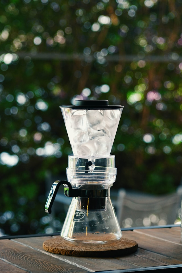 Espresso machine with a glass of water and a water filter pitcher on a bright counter